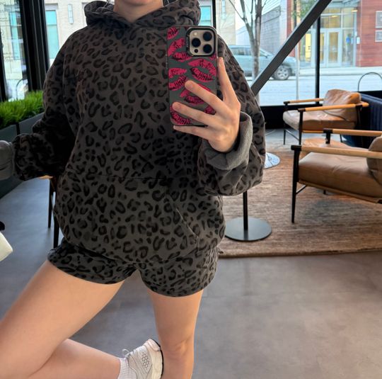 Customer Makenzie wearing a black leopard Comfrt hoodie and matching shorts